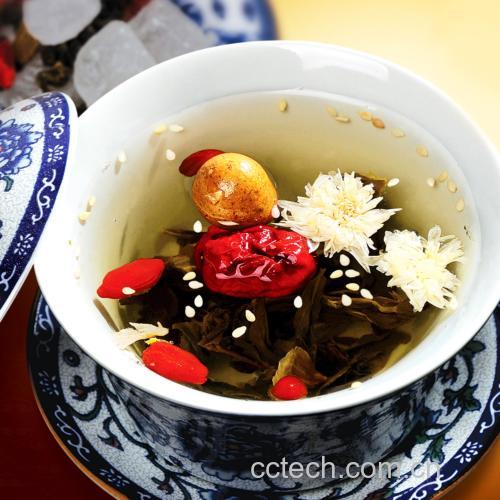 图片说明:一只白色陶瓷杯中正在注入热水,水中漂浮着数朵金黄色展开的黄花和十余粒红色枸杞,热气袅袅上升,旁边放有一小碟未冲泡的干黄花和枸杞,展示完整的冲泡场景,突出食材天然与养生氛围 黄花枸杞冲泡过程图