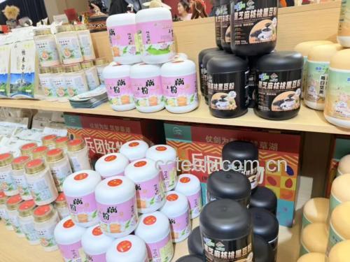 一位中年女性在超市保健食品货架前查看富硒平菇粉产品包装,手中拿着手机正在扫描二维码查看检测报告。货架上陈列多款类似产品,突出消费决策场景的真实性与信息验证的重要性 消费者购买富硒平菇粉场景图