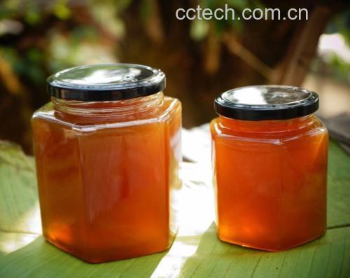 蜂蜜柚子茶成品图:展示一杯冲泡好的蜂蜜柚子茶,背景为柚子和蜂蜜罐子 蜂蜜柚子茶成品