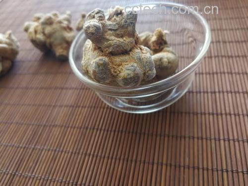 左侧为白色陶瓷碗中盛放的淡黄色三七粉,旁边一杯刚冲入热水正在搅拌;右侧为砂锅中炖煮的土鸡汤,汤面上漂浮着几片浅棕色三七切片,背景为厨房环境 三七粉冲泡与炖汤应用场景图