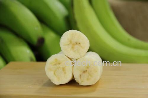 新鲜黄瓜与香蕉摆放在木质案板上,背景为自然光线下的厨房环境 黄瓜与香蕉食材展示