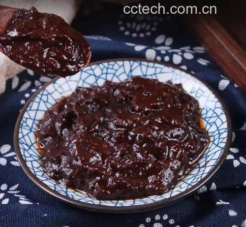 四川郫都区传统豆瓣酱晒场,成百上千个陶制酱缸整齐排列,工人正在翻搅缸内深红色的豆瓣酱。阳光照射下酱体油光发亮,空气中仿佛弥漫着发酵香气。展示传统工艺与大规模生产结合的场景 传统郫县豆瓣酱晒场发酵场景