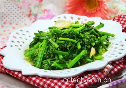 一盘刚出锅的油麦菜炒洋葱盛放在白色瓷盘中,菜色翠绿明亮,洋葱呈淡紫色条状分布其中,表面略有油光但不油腻,点缀少量红色辣椒段,背景为简约餐桌布置 成品油麦菜炒洋葱装盘效果