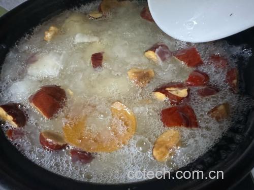 砂锅中小火慢炖,汤面微微冒泡,梨块与红枣、桂圆在金黄色汤液中翻滚,蒸汽袅袅升起,体现温暖养生氛围 梨红枣桂圆汤炖煮过程图