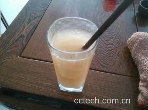 展示一瓶已经泡制完成的葛根酒,颜色微黄,瓶子上贴有标签,背景为自然光线下的架子 葛根酒成品展示