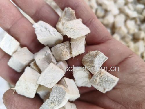厨房场景中一位厨师正在用蒸锅蒸制切块的葛根,蒸笼为竹制,周围有新鲜葛根原料、陶瓷碗、木筷和玻璃杯中的葛根粉,环境明亮整洁,体现家庭健康饮食氛围 葛根烹饪场景图
