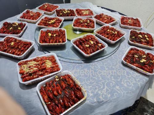 一家人围坐在餐桌旁,正在享用一锅热腾腾的麻辣小龙虾火锅,气氛温馨而欢乐 一家人围坐享用小龙虾火锅场景