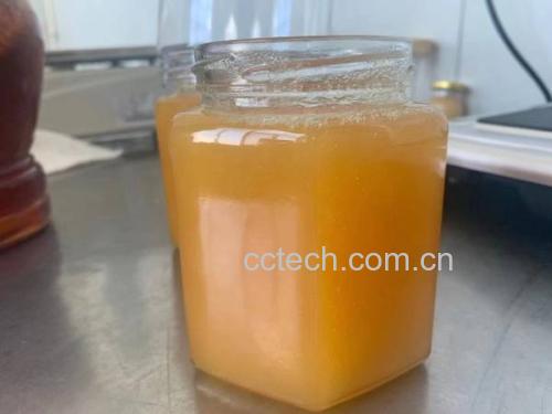 一瓶装满优质蜂蜜的玻璃罐,色泽金黄,质地浓稠,背景为自然蜂场 优质蜂蜜特写