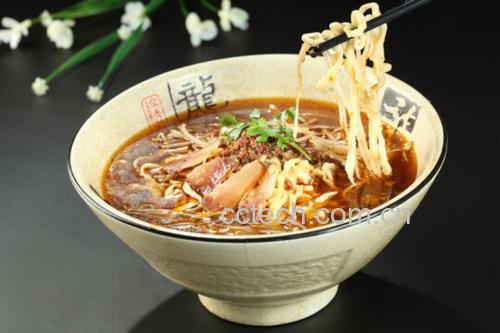 特写镜头下的一碗热腾腾的手工拉面,面条劲道,表面覆盖着一层油润透亮的红色辣椒油,点缀着翠绿葱花和白色芝麻,旁边放置一个透明玻璃罐,内盛自制辣椒油,背景为木质餐桌 一碗手工面条上淋满红亮辣椒油,撒有葱花和芝麻,旁边摆放木筷和辣椒罐
