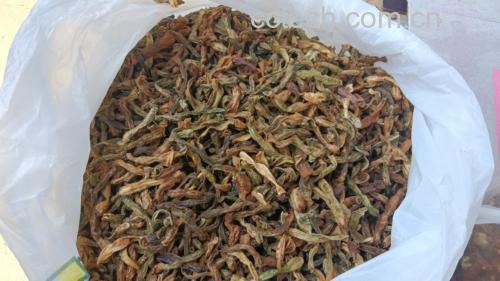 正宗泡椒臭干子出锅特写：油亮琥珀色豆干块堆叠，嵌着金黄泡椒与翠绿紫苏叶