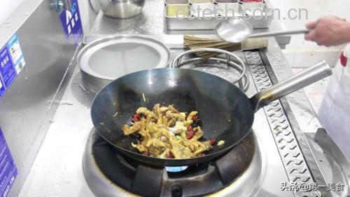一位家庭厨师正在厨房中用铁锅翻炒红菜苔,锅中菜薹呈紫红色,配以蒜片和红椒丝,热气腾腾,灶台旁摆放着新鲜的红菜苔原料和调味料瓶罐,光线温暖,展现家常烹饪的真实氛围 家庭厨房中烹饪红菜苔的场景