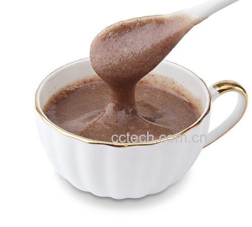 一碗热气腾腾的白扁豆薏米粥,呈乳白色糊状,表面有细腻油光,旁边摆放着木勺和青瓷碗,背景为厨房台面,体现家常养生氛围 白扁豆烹饪成品图