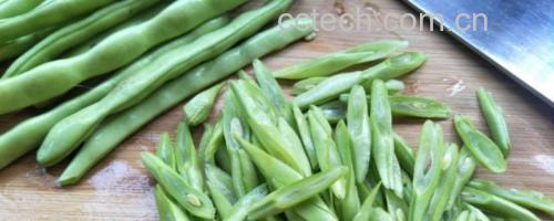 厨师手持菜刀正在砧板上斜切无筋豆,豆子呈翠绿色,刀法精准,切口平整 厨师手持菜刀正在砧板上斜切无筋豆,豆子呈翠绿色,刀法精准,切口平整