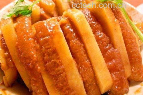 烹饪过程特写:炒糖色后的排骨翻炒场景,突出红亮色泽与浓郁香气 厨师正在用锅铲翻炒已上色的排骨,锅中冒着热气,糖色红亮,排骨均匀裹着酱汁