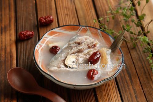 一碗盛满乳白色多宝鱼炖汤的陶瓷碗,鱼块清晰可见,配有豆腐和葱花点缀,旁边放着木筷和小碟咸菜,背景为木质餐桌,氛围温馨 图片描述