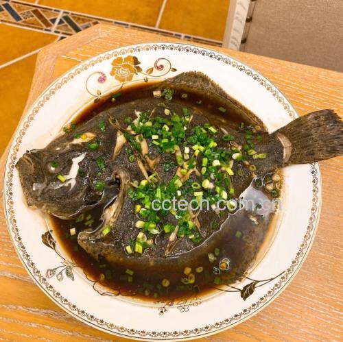 一口不锈钢蒸锅正在使用中,锅盖半开,白色蒸汽升腾,锅内清晰可见一条摆放在葱段上的多宝鱼,鱼身上铺满红色剁椒和蒜末混合物,旁边计时器显示时间为8分30秒 蒸制过程示意图