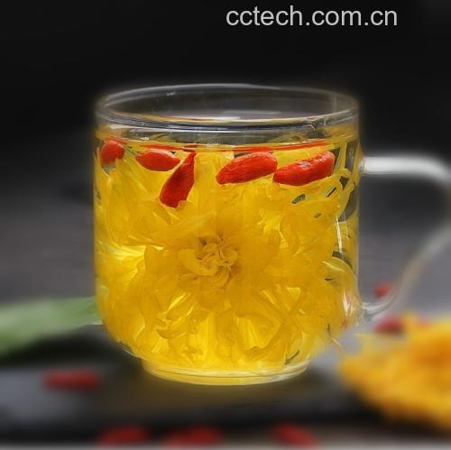 一只透明玻璃杯中盛有淡黄色的野菊花茶,两朵完整的野菊花悬浮其中,杯口微微冒着热气,旁边摆放一小碟蜂蜜,整体画面温馨健康,突出饮品的天然与养生属性 冲泡后的野菊花茶饮品