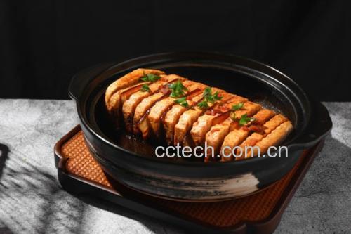 砂锅中正在炖煮的红烧肉,汤汁呈红棕色,油光发亮,肉块表面已呈现诱人的酱红色,锅边可见微微沸腾的小气泡,周围散落着姜片和香料 炖煮过程特写