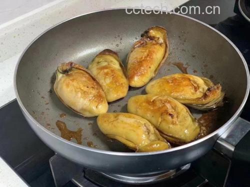 锅中煎制的生蚝配以香料和蔬菜的美食场景 烹饪中的生蚝菜肴
