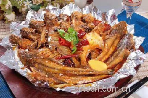 金黄色的香煎带鱼摆盘精致,旁边有葱花和柠檬片装饰 煎好的带鱼成品图