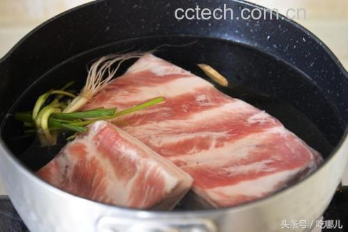 木质砧板上整齐摆放着切好的五花肉块、几片干制山楂、生姜片、八角、香叶和桂皮,背景为砂锅和炉灶,整体呈现传统中式炖肉的准备场景 山楂干与炖肉食材摆放图