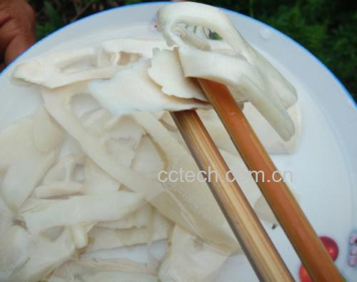 一盘色泽洁白、香气扑鼻的白油竹笋摆放在餐桌上,旁边配有米饭和筷子 白油竹笋成品图