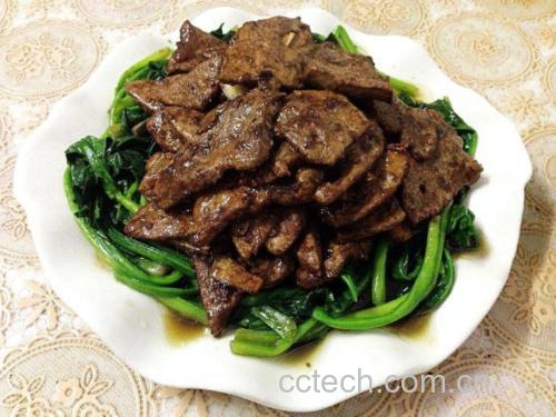 新鲜猪肝切片呈深红色,表面光滑有光泽;黄瓜为翠绿色长条状,表皮带刺,旁边配有姜片、蒜瓣等辅料,摆放在白色砧板上 猪肝与黄瓜食材特写