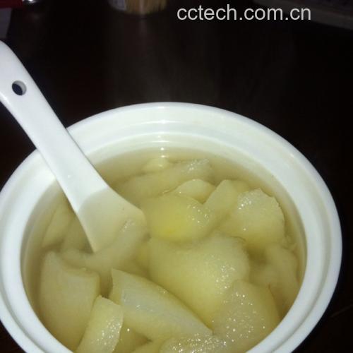 市场摊位上整齐摆放的黑色冻酸梨子与宣传牌