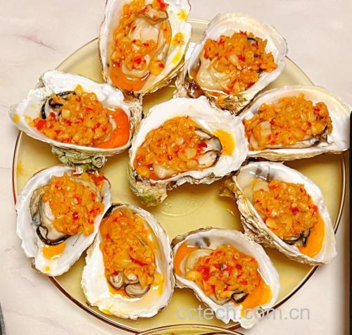 蒜蓉生蚝成品特写:金黄酥脆蒜蓉覆盖饱满乳白蚝肉,壳内汁水丰盈,表面可见细微焦糖化斑点