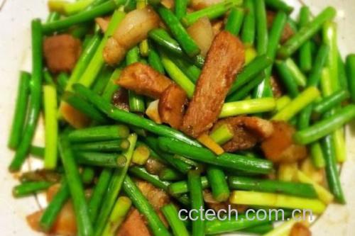 白帽蒜薹家常烹饪场景:不锈钢炒锅中青翠蒜薹段与鲜虾仁同炒,锅气升腾但无焦糊,灶具温度计显示115℃,旁边放置计时器定格在2分15秒