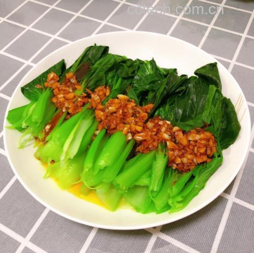 蒜蓉油菜成品特写：翠绿油菜整齐码放盘中，表面覆着金黄蒜蓉与细红椒丝，油光润泽不反光，叶脉清晰可见