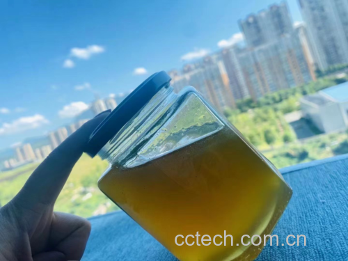 一杯温热的蜂蜜姜水放在木质桌面上，背景为清晨阳光透过窗户的温暖氛围