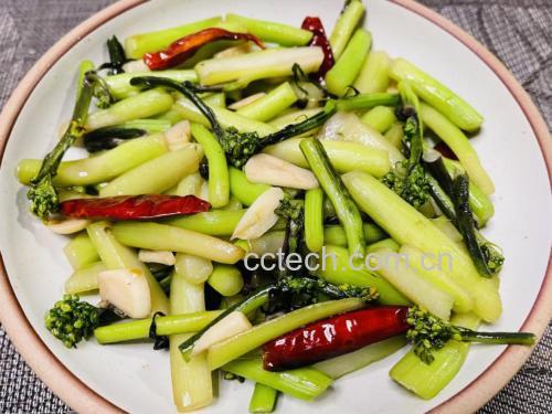 成品菜肴盛放在白色瓷盘中,红菜苔紫红油亮,白菜苔嫩绿清雅,整体色彩对比鲜明,撒有少量蒜末点缀,旁边配有木筷与一碗白米饭