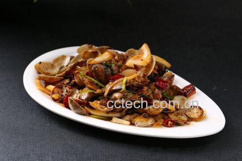 一盘红亮诱人的辣炒花蛤盛在蓝色陶瓷盘中,配以青红椒丝和葱花点缀,背景为木质餐桌