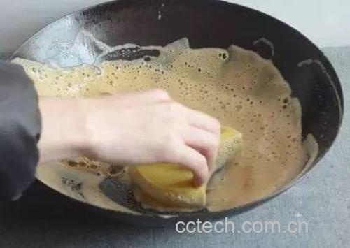 厨房台面操作场景：左手持厚底蓝釉珐琅锅（锅内可见微沸状态），右手执细网勺正轻柔撇去浮沫，背景为计时器显示“08:42”，台面散落洗净的百合与绿豆，光线明亮突出操作专注感