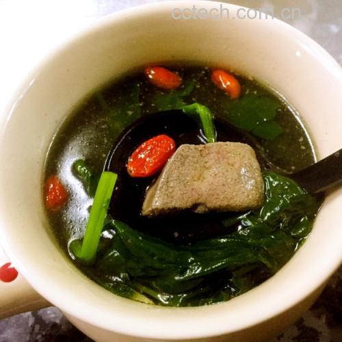 菠菜熬猪肝汤特写：翠绿菠菜叶与深褐色猪肝片在清亮琥珀色汤中自然分布，汤面浮有细微油星，无添加调味料痕迹，体现原生态烹饪