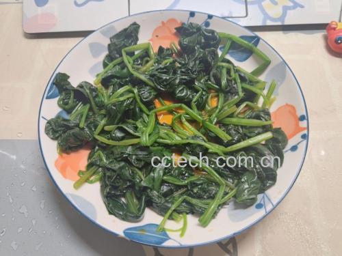 家庭厨房中正在翻炒菠菜与枸杞