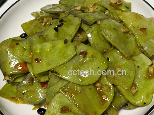 专业厨房实拍：不锈钢炒锅中绿扁豆与蒜末同炒，豆荚保持鲜翠欲滴色泽，锅气升腾但无焦糊，计时器显示1分50秒