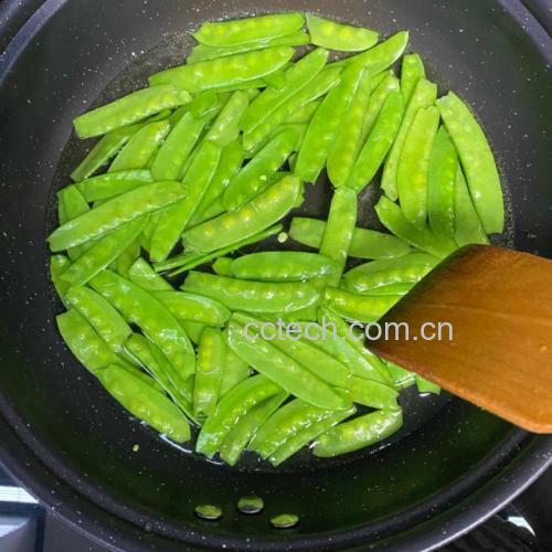 家庭厨房中正在烹饪青豌豆的场景