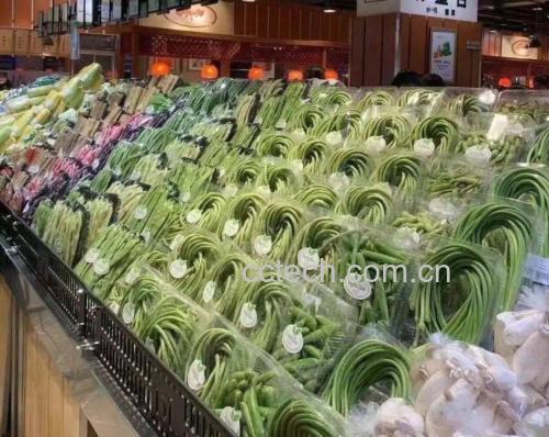 超市货架上整齐摆放的新鲜豆角与芹菜商品陈列