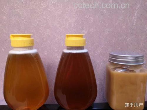 一张对比图展示三种不同颜色的蜂蜜样品(浅黄色、琥珀色、深褐色)置于白色瓷勺上,背景为蜂箱与开花植物景观