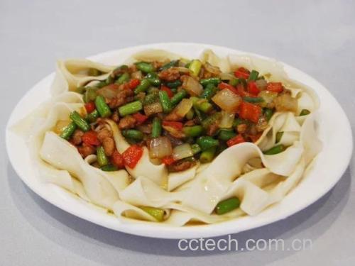 一碗热腾腾的手工面条被小米椒剁辣椒染成微红色,配有青菜和卤蛋