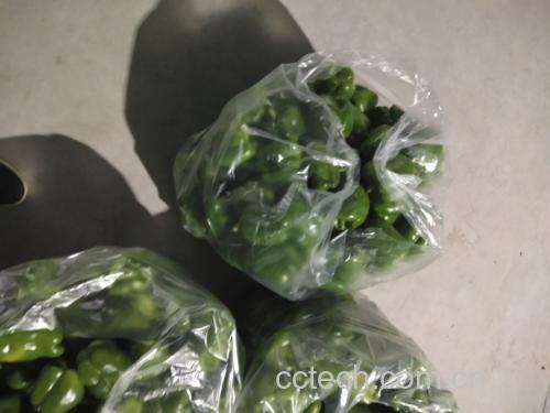 新鲜青红尖椒平铺在竹筛上晾晒