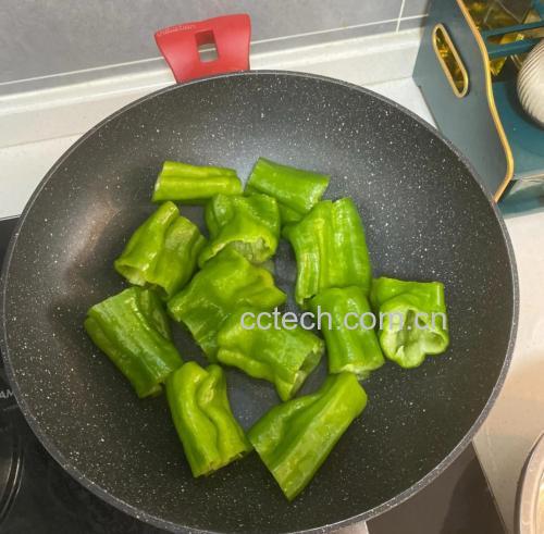 厨房中正在烹饪线椒菜肴的场景