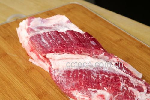 厨房中切分肥瘦相间猪肉的特写镜头