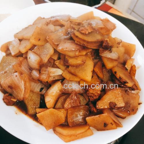 锅中正在翻炒洋葱与土豆片的特写