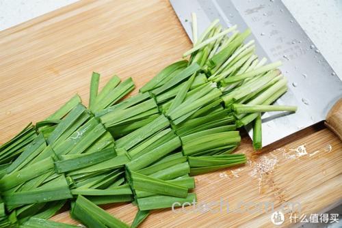 新鲜韭菜在砧板上被切成段准备烹饪