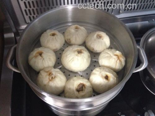 蒸锅中红皮萝卜包子正在蒸制,热气腾腾,诱人食欲