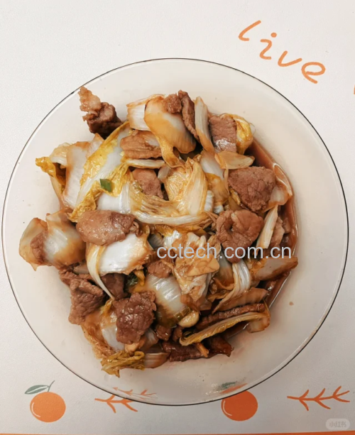白不老炒肉正在锅中翻炒，肉片与蔬菜均匀混合，香气扑鼻