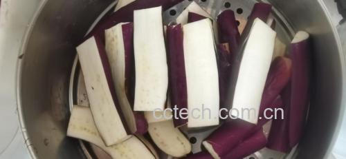 蒸熟的茄子整齐摆放在蒸盘中，表面微微发亮